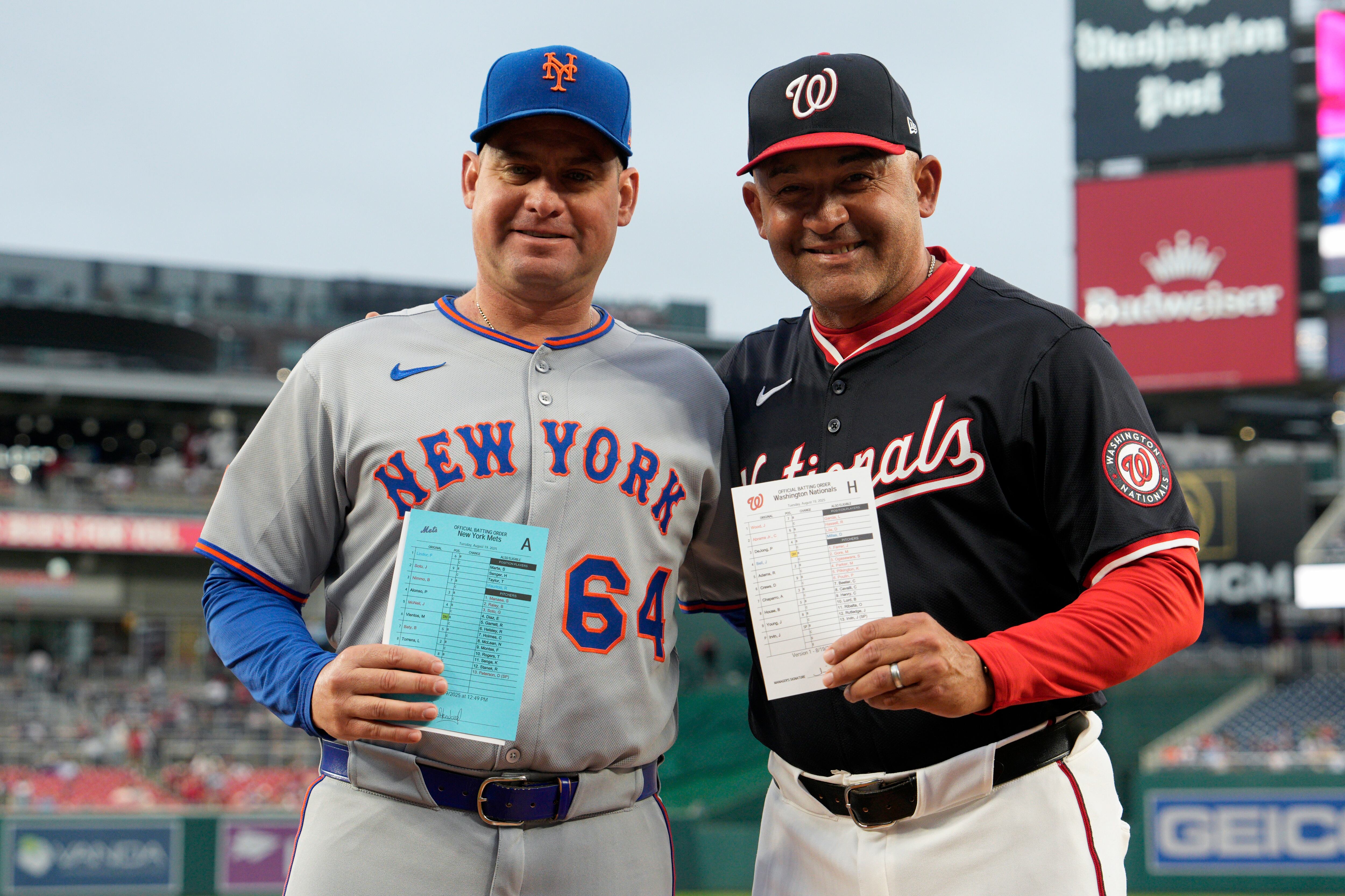 WASHINGTON, DC - AUGUST 19: Managers Carlos Mendoza #64 of the New York Mets and Miguel Cairo #22 of the Washington Nationals pose for a photo after delivering the lineup cards before a game at Nationals Park on August 19, 2025 in Washington, DC. This marks the first game in Major League history to feature two Venezuelan-born managers. (Photo by Jess Rapfogel/Getty Images)