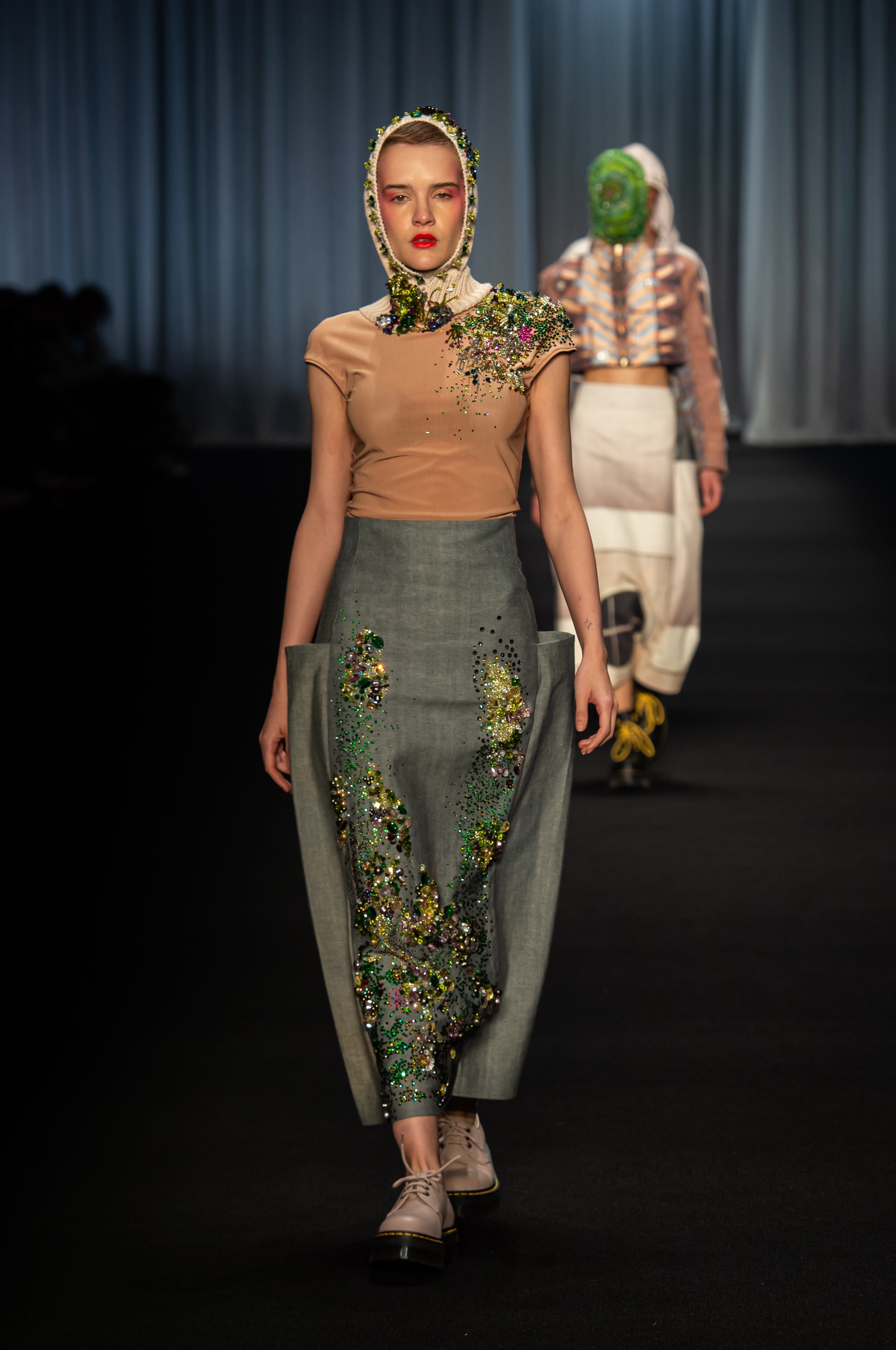 Silueta estructurada en tonos neutros desfilando en la colección del Istituto Marangoni.