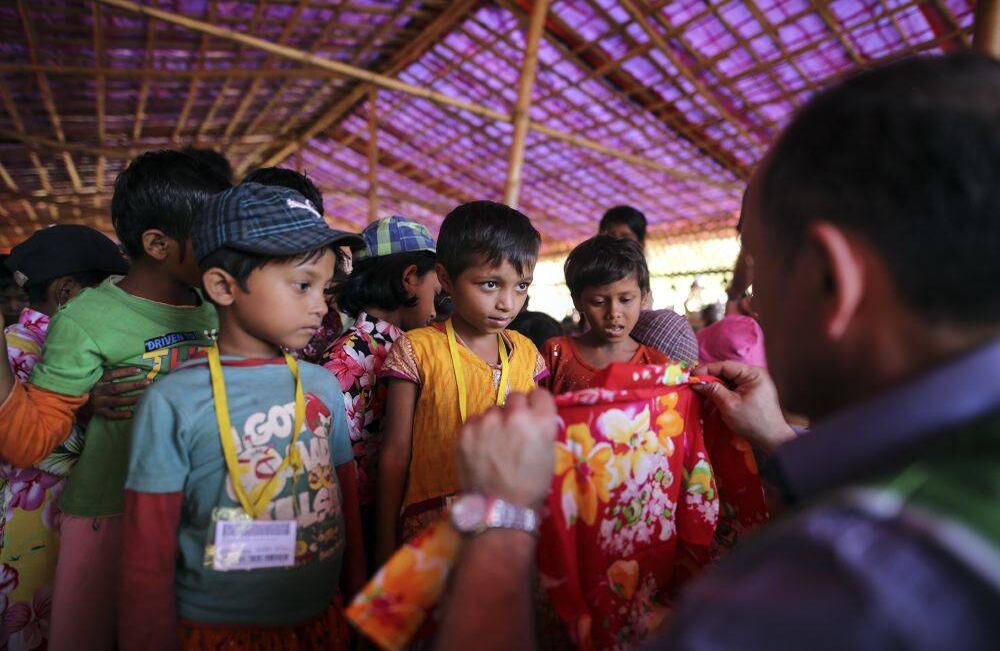 Miembros de Humanitarian Relief Foundation (IHH) distribuyen ropa, zapatillas y zapatos a los niños rohingya en el campamento de refugiados en Balukhali en Cox's Bazar, Bangladesh el 3 de diciembre de 2017. Desde el 25 de agosto, 515,000 rohingyas cruzaron desde el estado occidental de Rakhine, en Myanmar, hasta Bangladesh, según la ONU. (Firat Yurdakul - Agencia Anadolu)