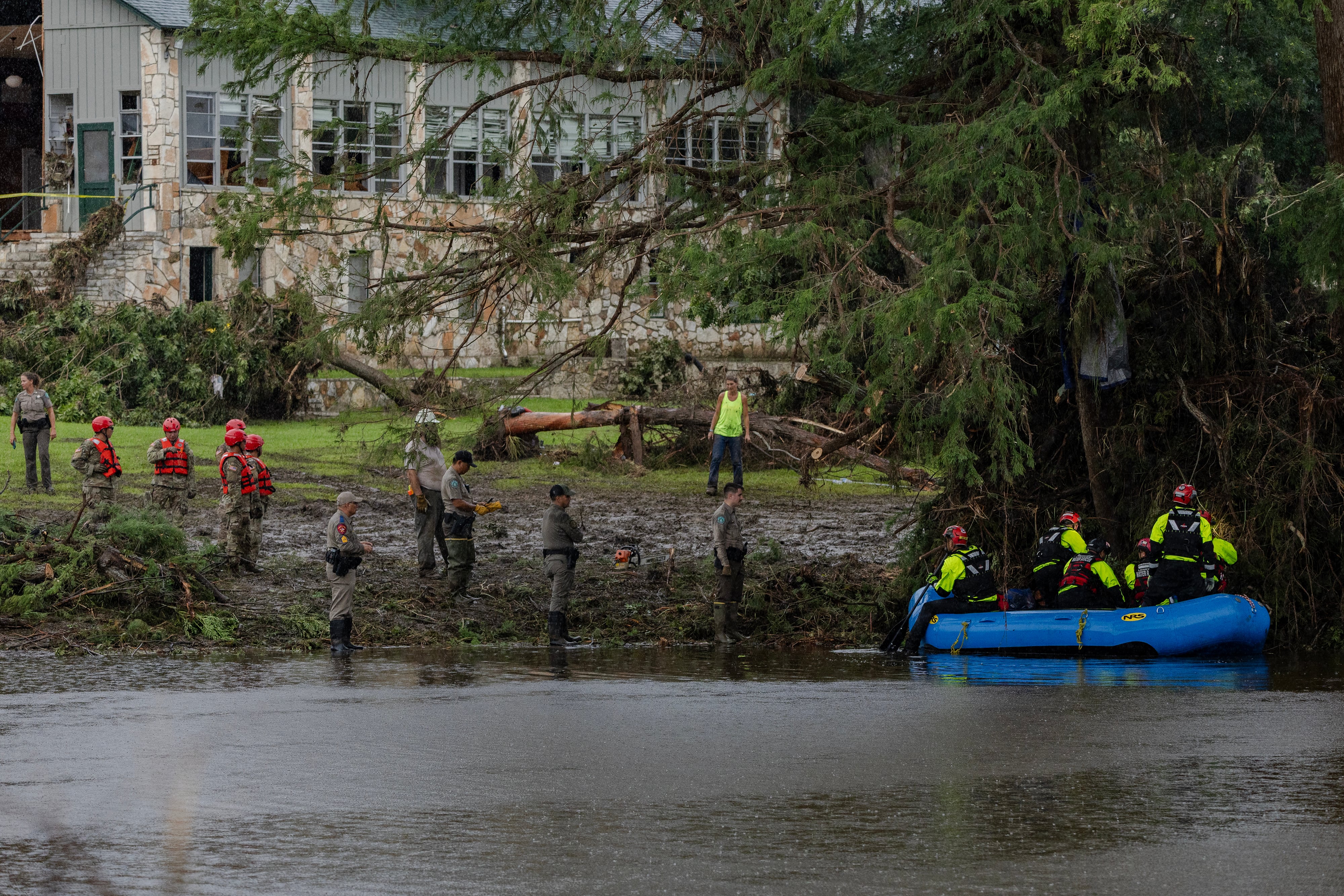 Los equipos de búsqueda y rescate excavan entre los escombros en busca de sobrevivientes o restos de personas arrastradas por la inundación repentina en Camp Mystic
