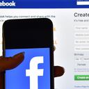 LONDON, ENGLAND - AUGUST 03: A person holds an iPhone displaying the Facebook app logo in front of a computer screen showing the facebook login page on August 3, 2016 in London, England. (Photo by Carl Court/Getty Images)