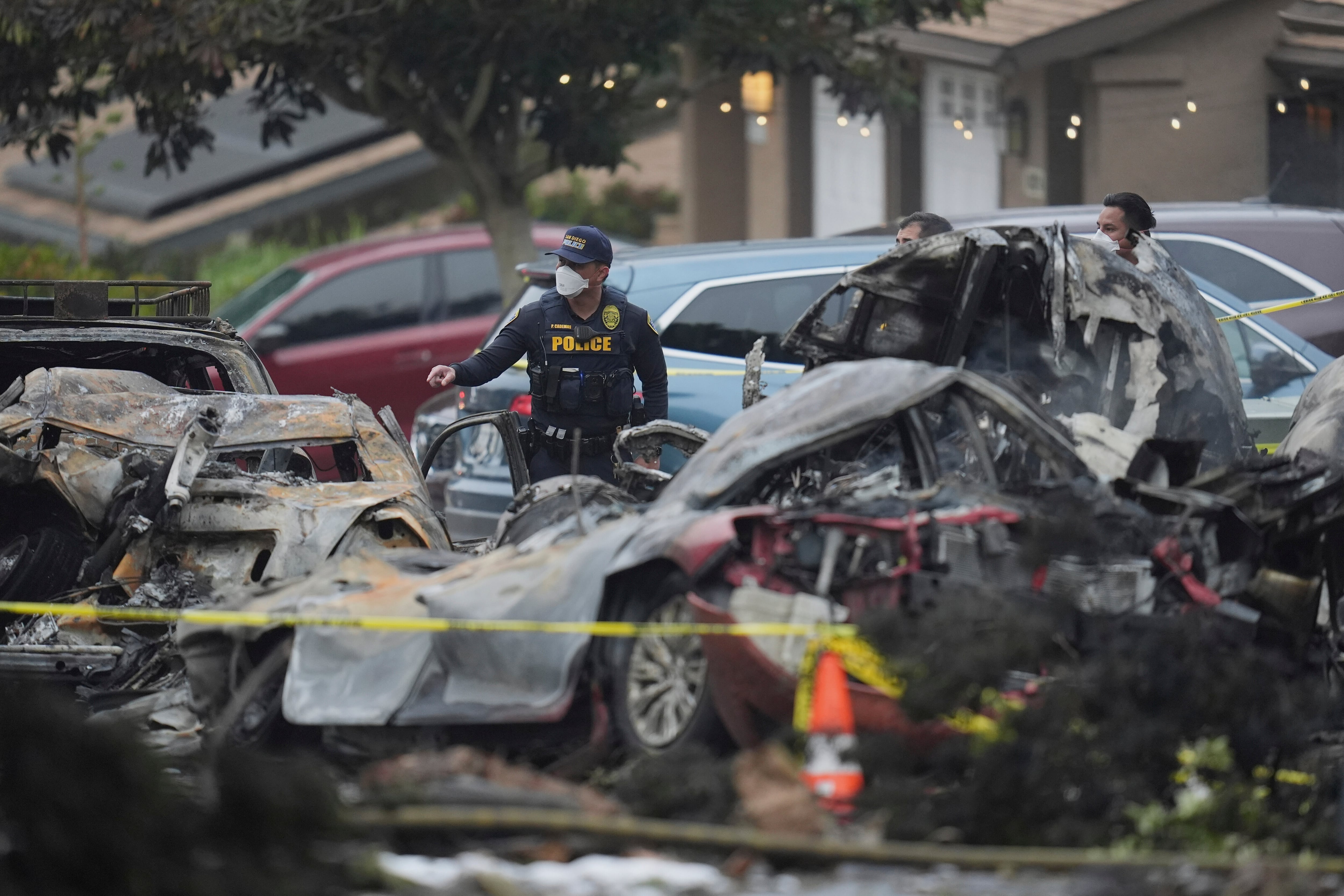 Authorities work the scene where a small plane crashed into a San Diego neighborhood, setting several homes on fire and forcing evacuations along several blocks early Thursday, May 22, 2025. (AP Photo/Gregory Bull)