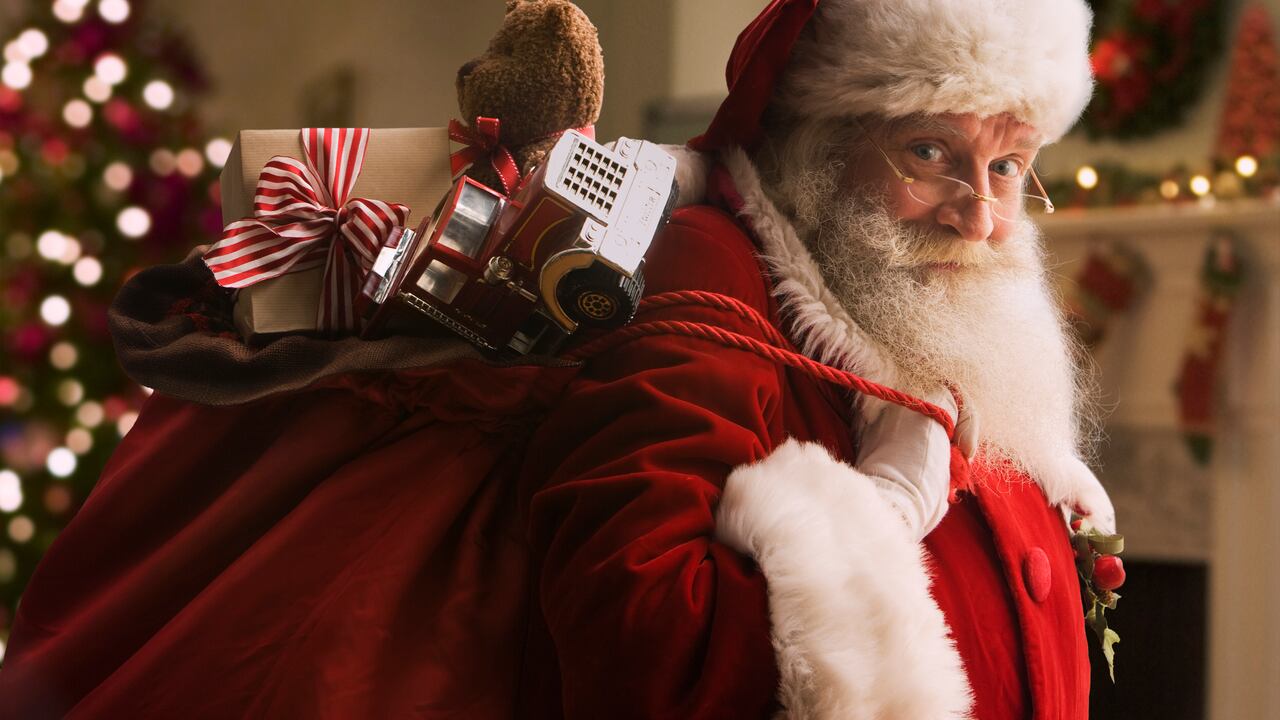 Santa Claus llevando una bolsa con regalos.