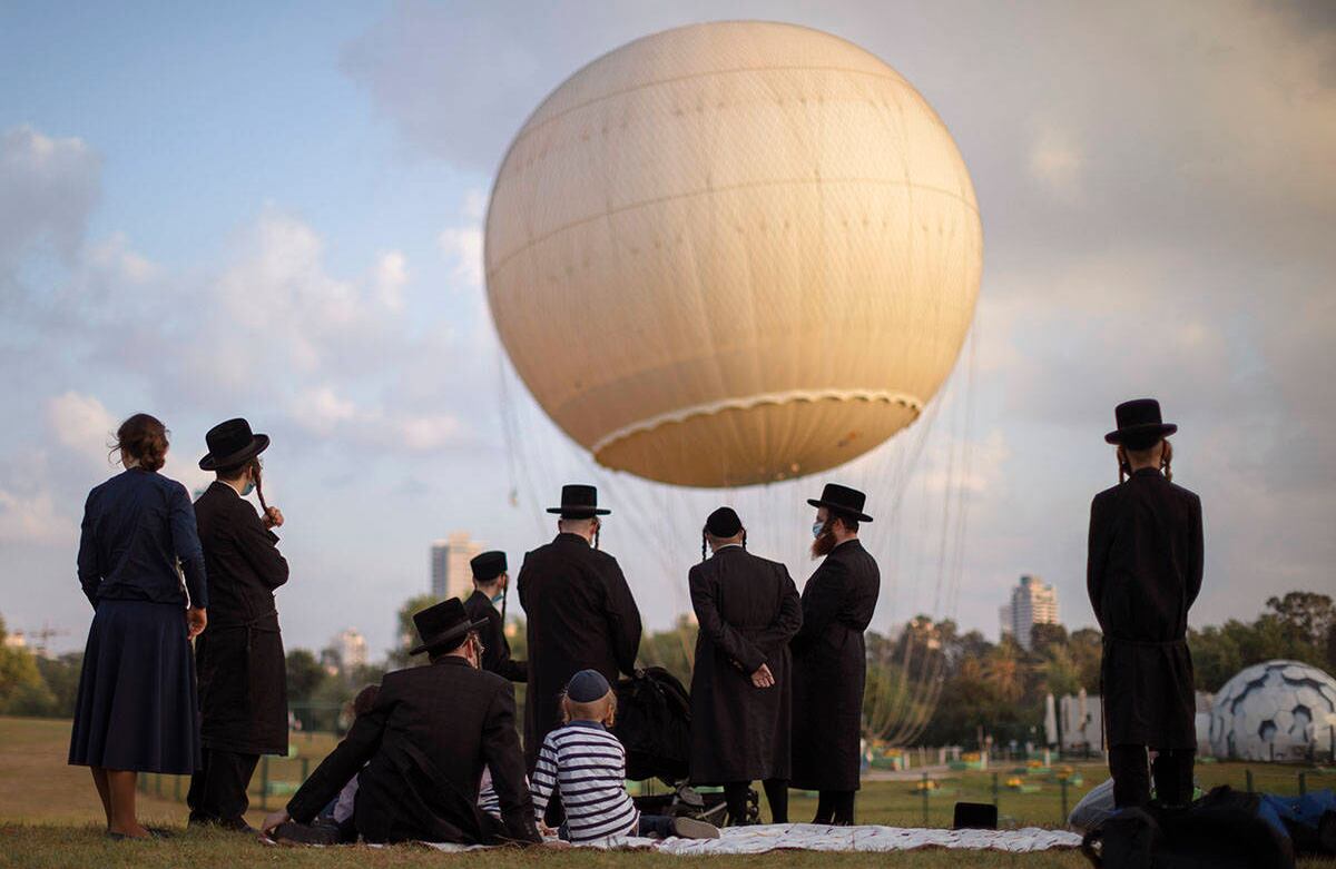 Judíos ultraortodoxos, algunos con mascarilla protectora, pasan el día en un parque de Tel Aviv, Israel, el miércoles 12 de agosto. Los estudiantes del centro de estudios Yeshivá disfrutan del Bein Hazmanim, un tiempo de dos semanas para pasar las vacaciones de verano. Foto: Oded Balilty / AP  