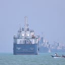 Un pequeño bote pasa frente a embarcaciones ancladas en el estrecho de Ormuz, frente a Bandar Abbas, Irán.