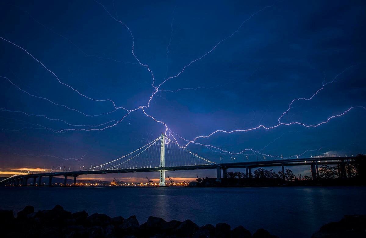Un rayo ilumina el cielo sobre el tramo este del Puente de la Bahía mientras una tormenta atravesaba el área el domingo por la mañana en San Francisco, el 16 de agosto de 2020. Foto: Carlos Ávila González / San Francisco Chronicle vía AP