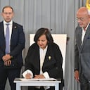 La representante de la oposición venezolana, Dinorah Figuera, firma un acuerdo junto al diputado Jorge Rodríguez.