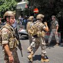 Soldados del ejército (frente) y fuerzas de seguridad (detrás) se reúnen frente a una sucursal del "Banco Federal" en la capital del Líbano, Beirut, el 11 de agosto de 2022. - Un cliente armado con un rifle y que amenazaba con prenderse fuego tomó como rehenes a trabajadores bancarios el 11 de agosto en La capital del Líbano exigió retirar sus ahorros de más de $ 200,000, dijeron fuentes de seguridad. El incidente es el más reciente entre los bancos locales y los depositantes enojados que no pueden acceder a sus ahorros después del colapso económico del Líbano debido a los controles de capital informales. Un corresponsal de AFP vio a las fuerzas de seguridad rodeando una sucursal cerca de la concurrida calle comercial Hamra en el oeste de Beirut. (Foto de anwar amro / AFP)