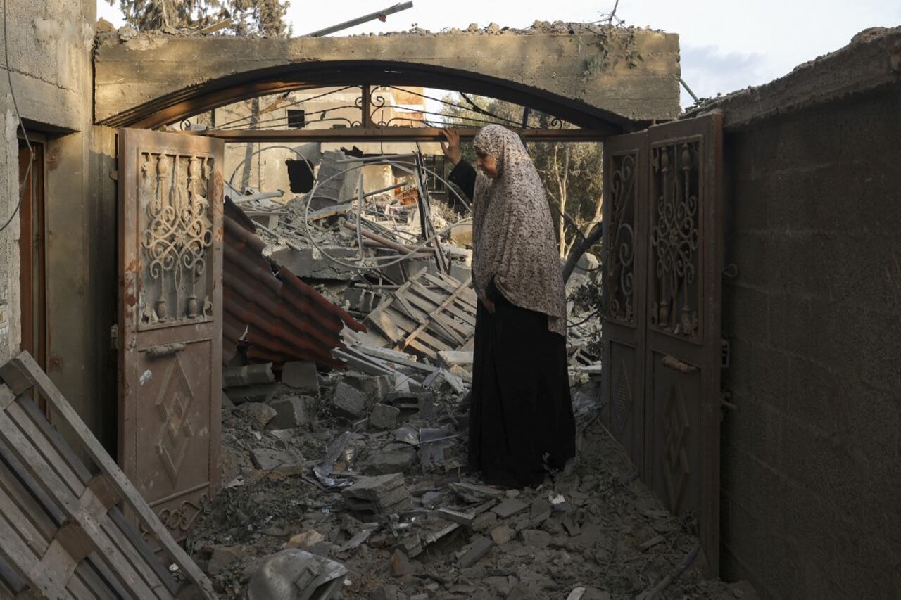 Una mujer inspecciona los daños en su hogar después de los ataques israelíes en el campamento de Rafah, en el sur de la Franja de Gaza, el 14 de octubre de 2023. Miles de palestinos huyeron el 14 de octubre al sur de Gaza en busca de refugio después de que Israel les advirtiera que evacuaran antes de una ofensiva terrestre esperada en represalia por el ataque más mortífero en la historia de Israel.