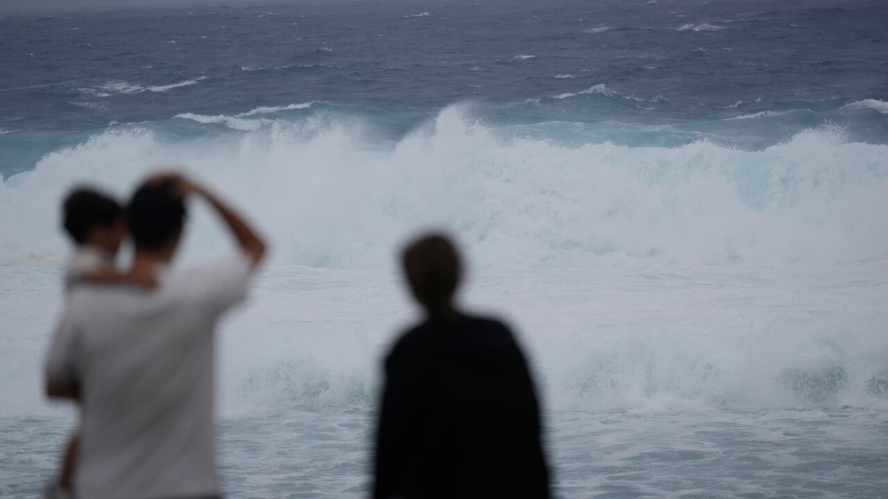 Varias personas de una misma familia observan el oleaje provocado por la cercanía del tifón Mawar en Itoman, en el sur de Japón, el 31 de mayo de 2023. (AP Foto/Hiro Komae)