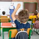 Niño en la escuela haciendo preguntas a una enfermera sobre la pandemia de COVID-19 - conceptos educativos