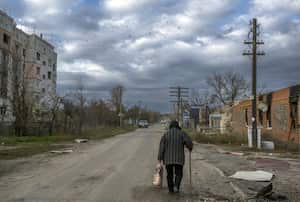 Una anciana camina en la aldea de Arkhanhelske, en la región de Kherson, el 3 de noviembre de 2022, que anteriormente estaba ocupada por las fuerzas rusas. (Foto de BULENT KILIC / AFP