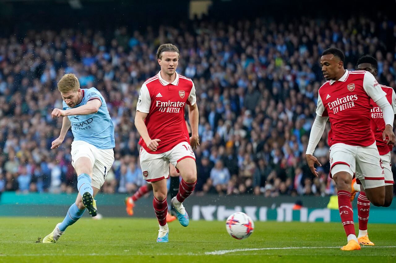 Manchester City's Kevin De Bruyne, left, scores the opening goal during the English Premier League soccer match between Manchester City and Arsenal at Etihad stadium in Manchester, England, Wednesday, April 26, 2023. (AP Photo/Dave Thompson)