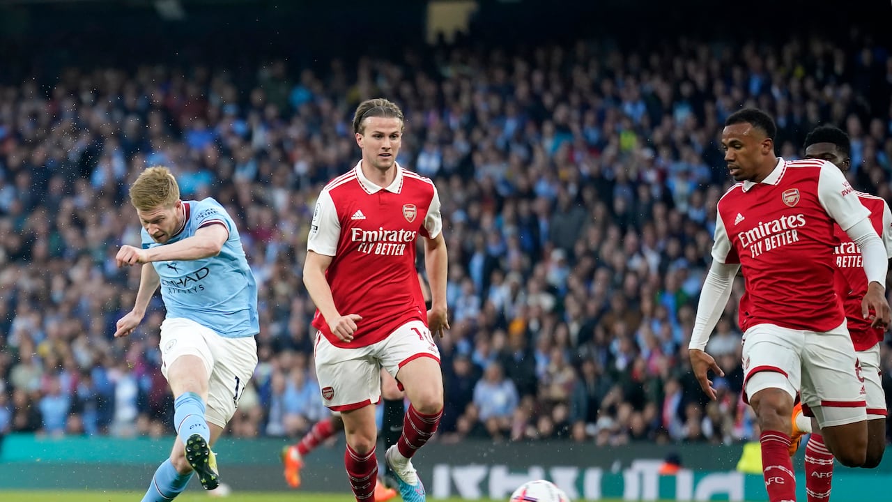 Manchester City's Kevin De Bruyne, left, scores the opening goal during the English Premier League soccer match between Manchester City and Arsenal at Etihad stadium in Manchester, England, Wednesday, April 26, 2023. (AP Photo/Dave Thompson)