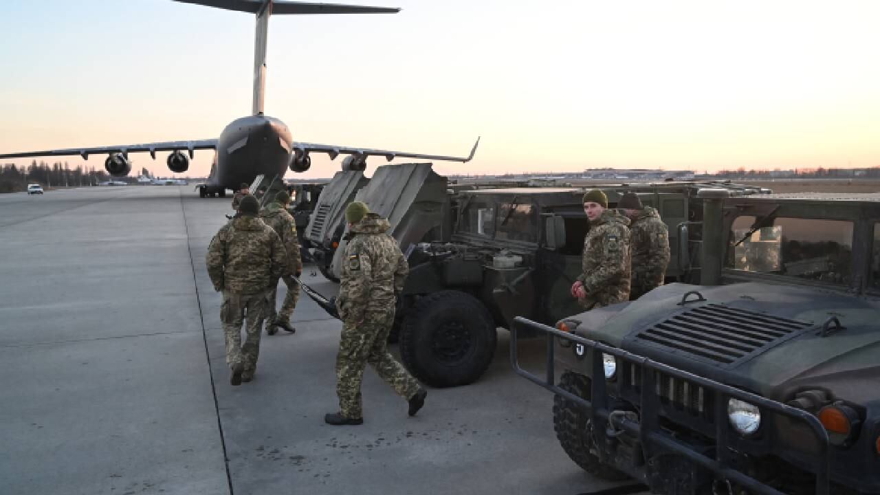 Soldados de las fuerzas militares ucranianas examinan los camiones militares de vehículos de ruedas multipropósito de alta movilidad (HMMWV) enviados desde Lituania al aeropuerto de Boryspil en Kiev.