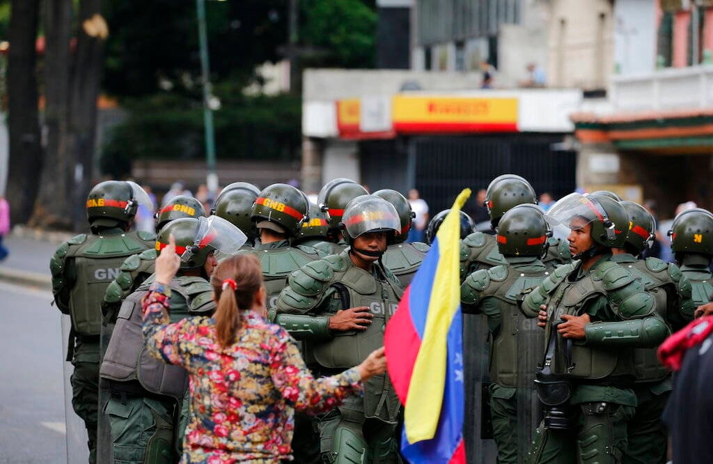 Una mujer se enfrenta a la guardia nacional por impedir el paso de los manifestantes. Crédito: AP Photo/Fernando Llano