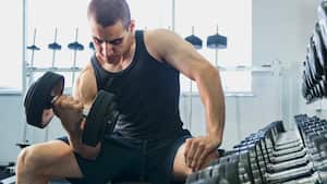 Hombre en el gimnasio realizando ejercicios para fortalecer los bíceps