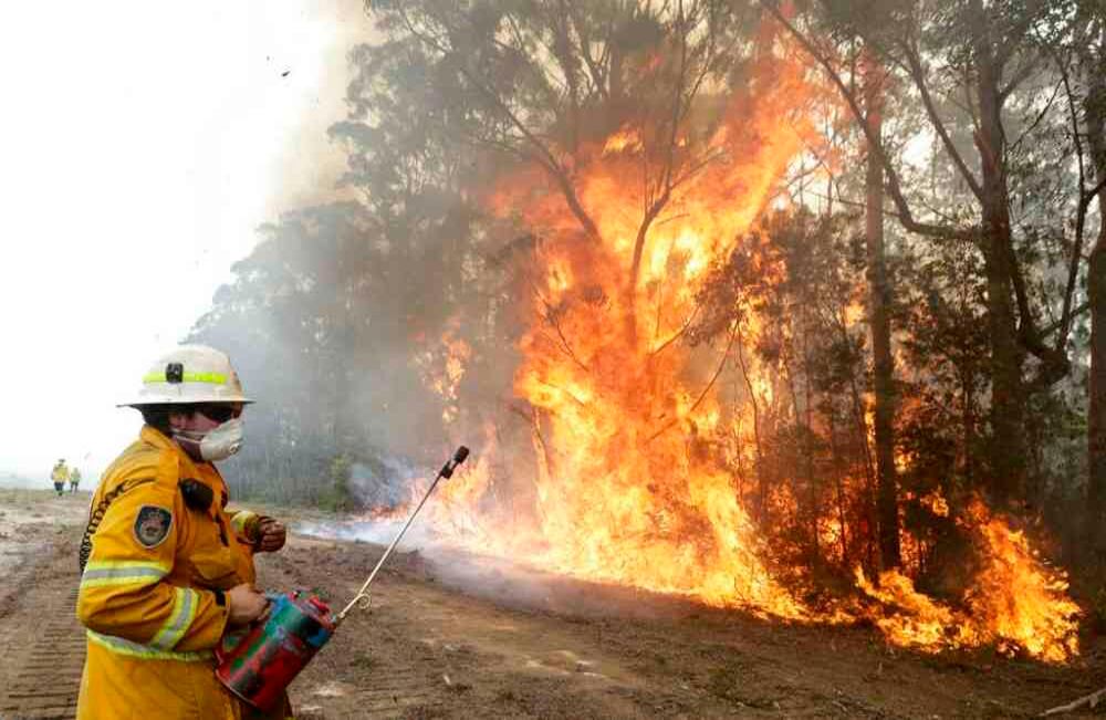 Los bomberos, que luchan incansablemente para detener los incendios que afectan al país australiano, se alejan de las llamas luego de encender una quemadura controlada cerca de Tomerong, pueblo ubicado en la región de la costa sur de Nueva Gales del Sur, con el fin de contener un incendio más grande que se encuentra en una región cercana, el miércoles 8 de enero de 2020.  Foto de Rick Rycroft/AP