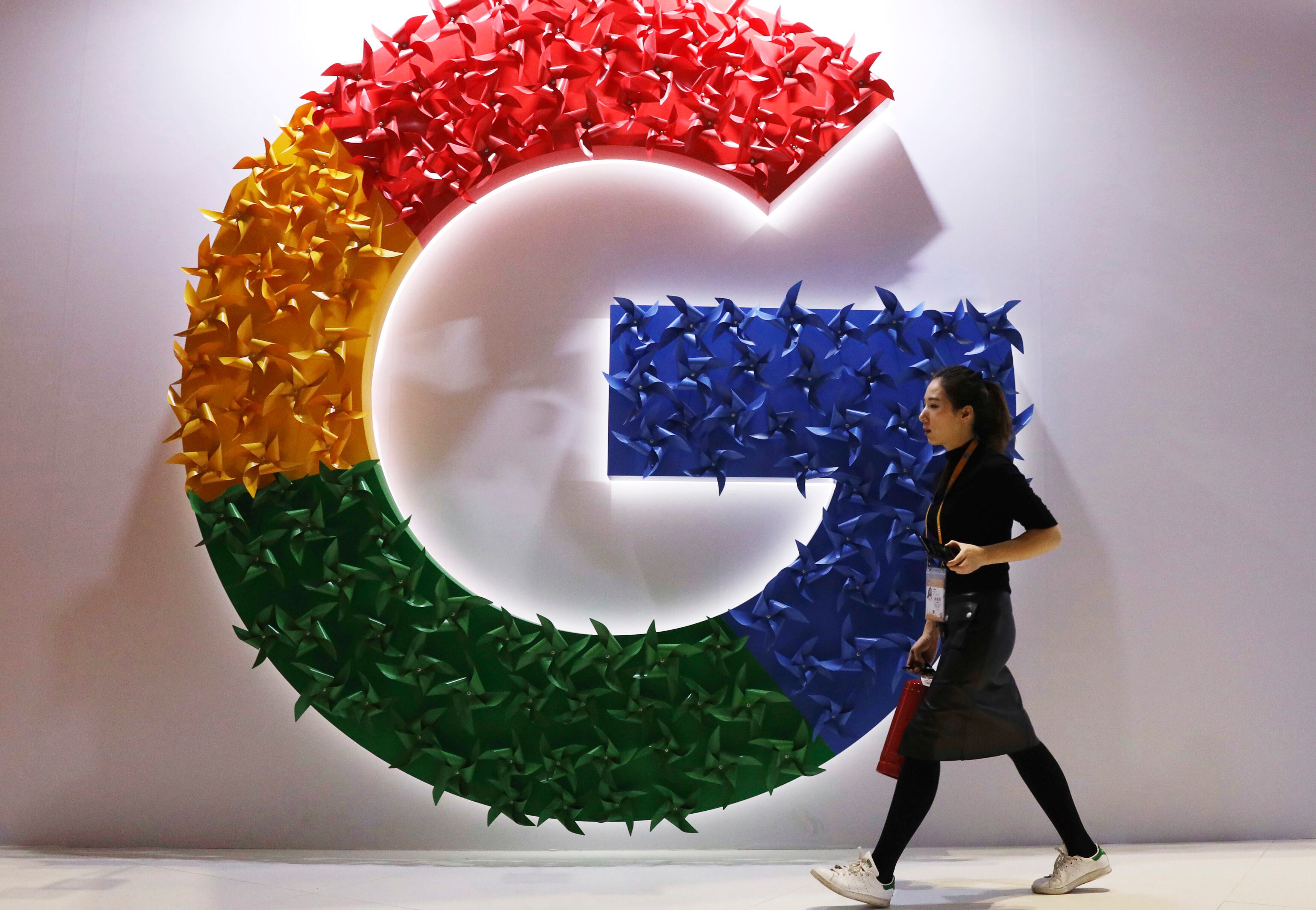 Una mujer caminando frente al logo de Google en la feria China International Import Expo, en Shanghái. (AP Foto/Ng Han Guan, Archivo)