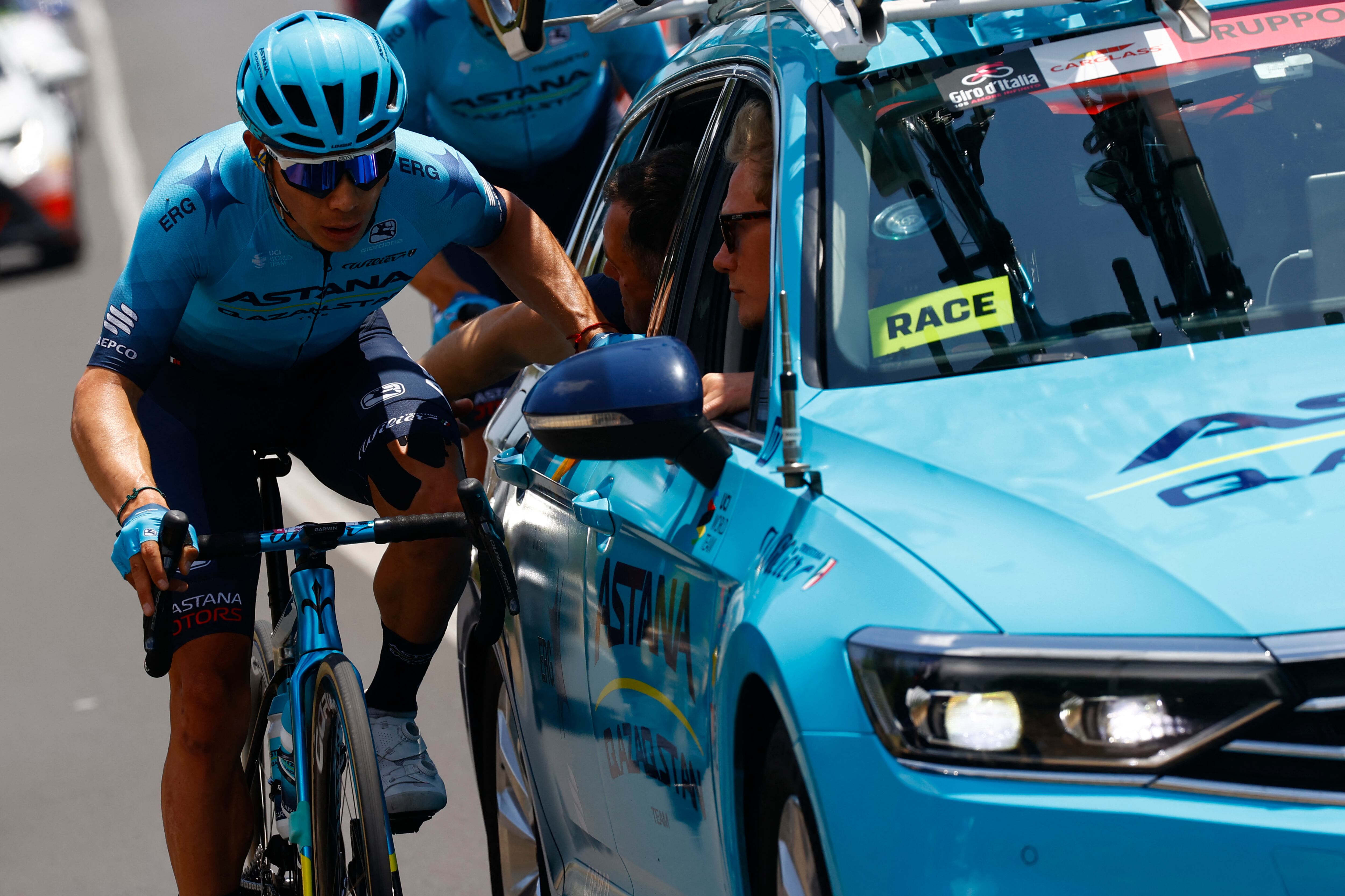 Team Astana's Colombian rider Miguel Angel Lopez talks to his sports team as he rides in the first kilometers of the 4th stage of the Giro d'Italia 2022 cycling race, 172 kilometers between Avola and Etna-Nicolosi, Sicily, on May 10, 2022. (Photo by Luca Bettini / AFP)
