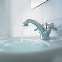 Cerca del lavabo del baño rebosante, lavamanos rebosado de agua, lleve abierta, grifo de agua, agua regandose.