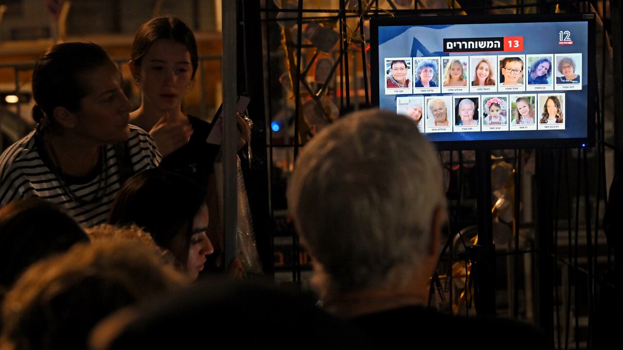 La gente ve las transmisiones de noticias mientras los rehenes son liberados en Egipto antes de ser llevados a Israel por el CICR, afuera del Museo de Tel Aviv el 24 de noviembre de 2023 en Tel Aviv, Israel. Esta mañana comenzó un alto el fuego de cuatro días entre Israel y Hamás, aunque las fuerzas israelíes permanecen en Gaza.
