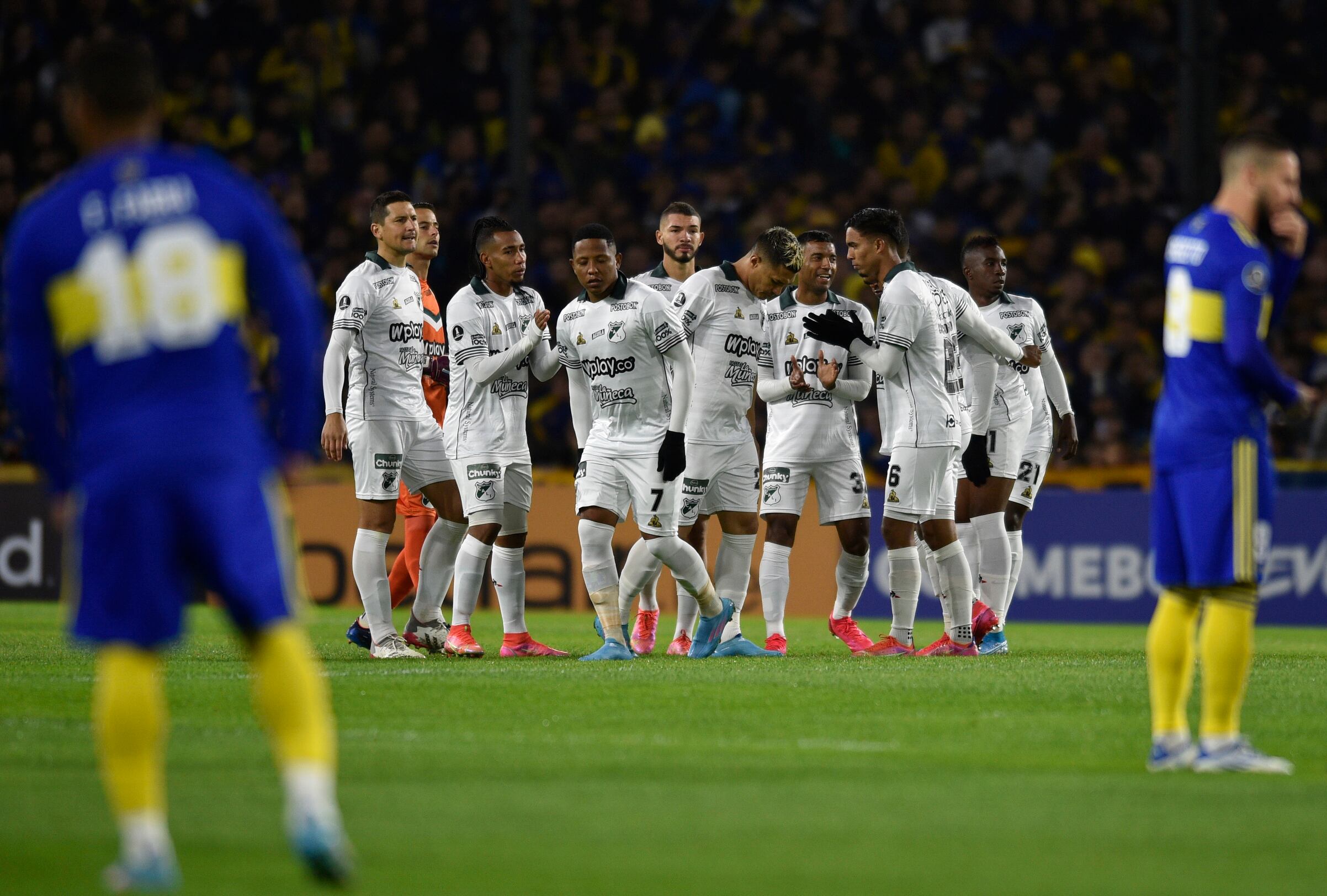 Players of Colombia's Deportivo Cali gather on the pitch prior to a Copa Libertadores soccer match against Argentina's Boca Juniors at the Bombonera stadium in Buenos Aires, Argentina, Thursday, May 26, 2022. (AP Photo/Gustavo Garello)