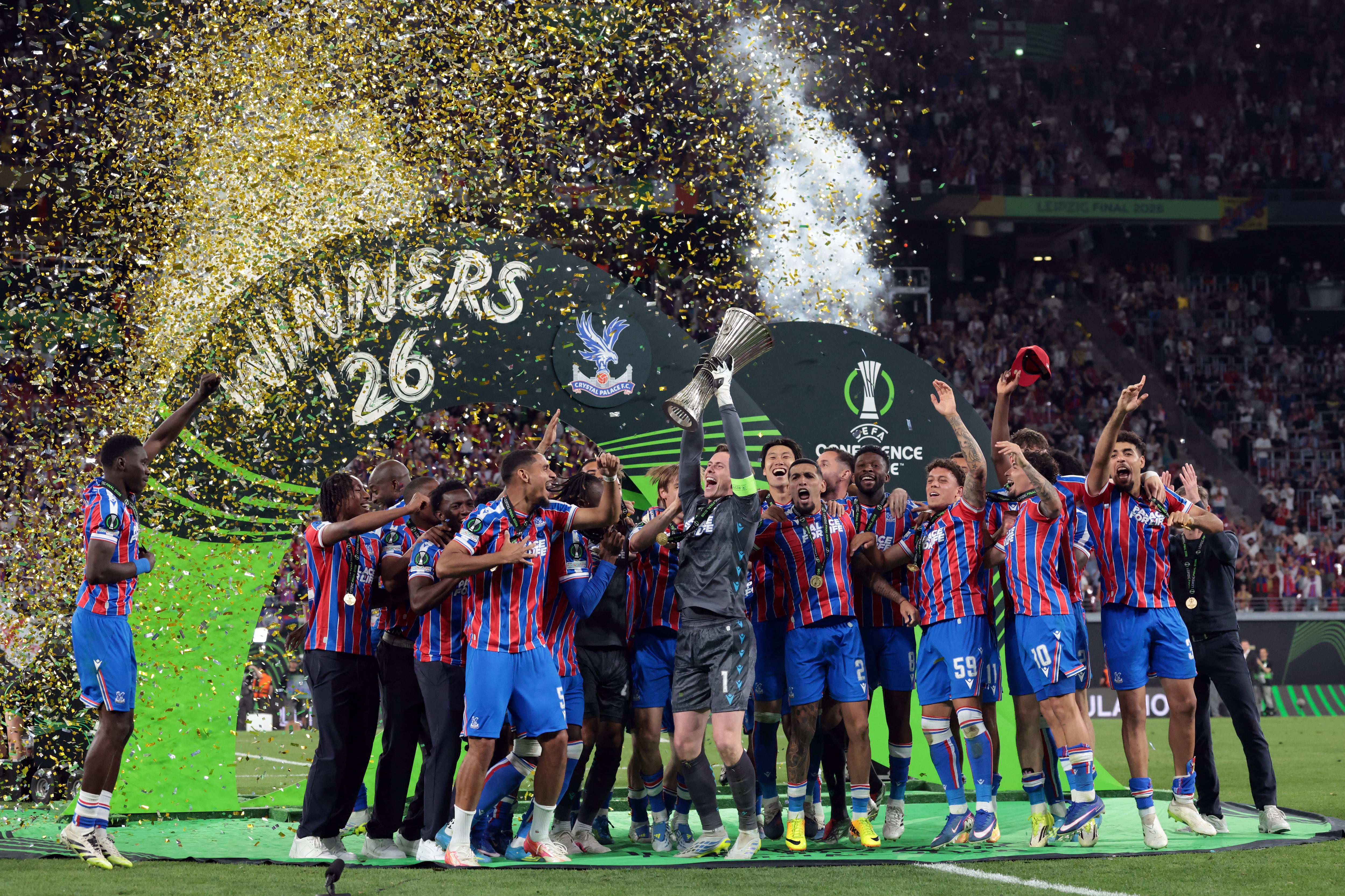 El portero inglés del Crystal Palace, Dean Henderson (C), levanta el trofeo mientras su equipo celebra la victoria en la final de la Liga de Conferencia de la UEFA entre el Crystal Palace FC y el Rayo Vallecano de Madrid en Leipzig, Alemania Oriental, el 27 de mayo de 2026. (Foto de Tobias SCHWARZ / AFP)