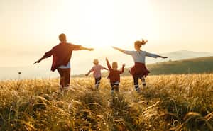 Familia feliz: madre, padre, hijos, hijo e hija al atardecer