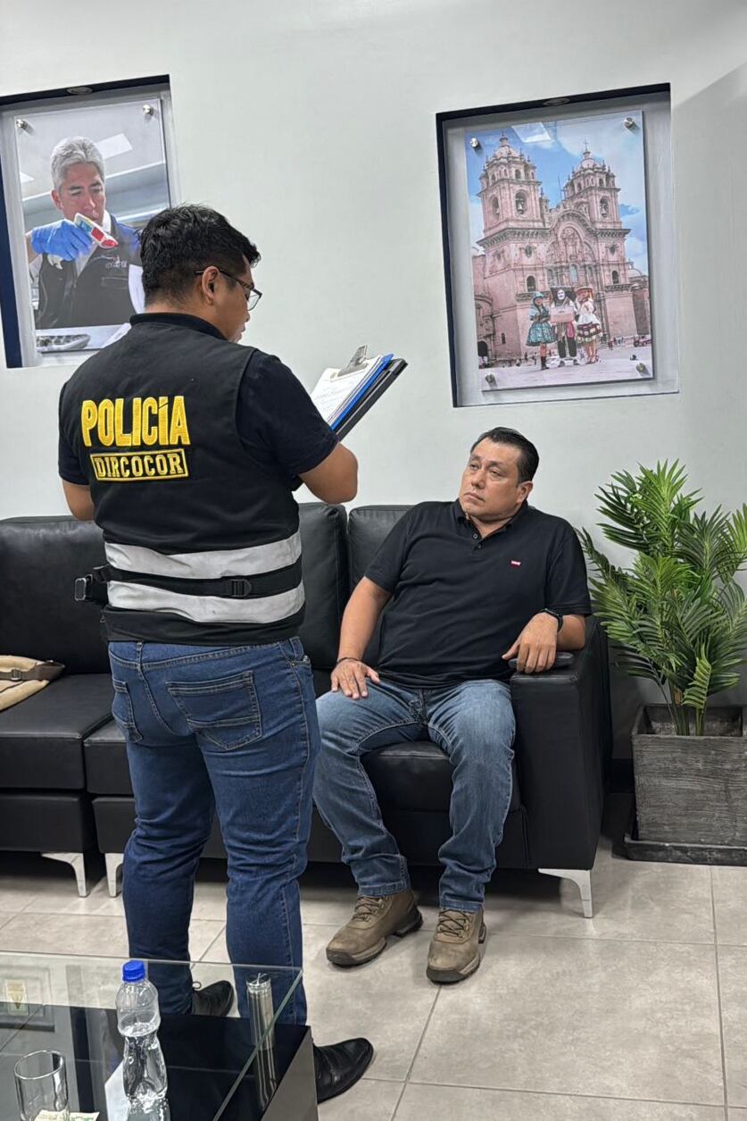 Esta fotografía, distribuida por la Policía Nacional del Perú, muestra la detención de José Edilberto Samame Blas (derecha), director de gestión electoral de la Oficina Nacional de Procesos Electorales (ONPE), por un agente de la policía anticorrupción en Lima el 13 de abril de 2026.