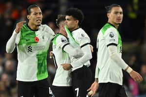 El colombiaano Luis Díaz del Liverpool es apoyado por su compañeros, tras marcar el gol del empate este domingo ante el Luton Town, en la Premer League 2023-2024, tanto que le dedicó a su papá secuestrado, Luis Manuel Díaz. /Foto JUSTIN TALLIS / AFP
