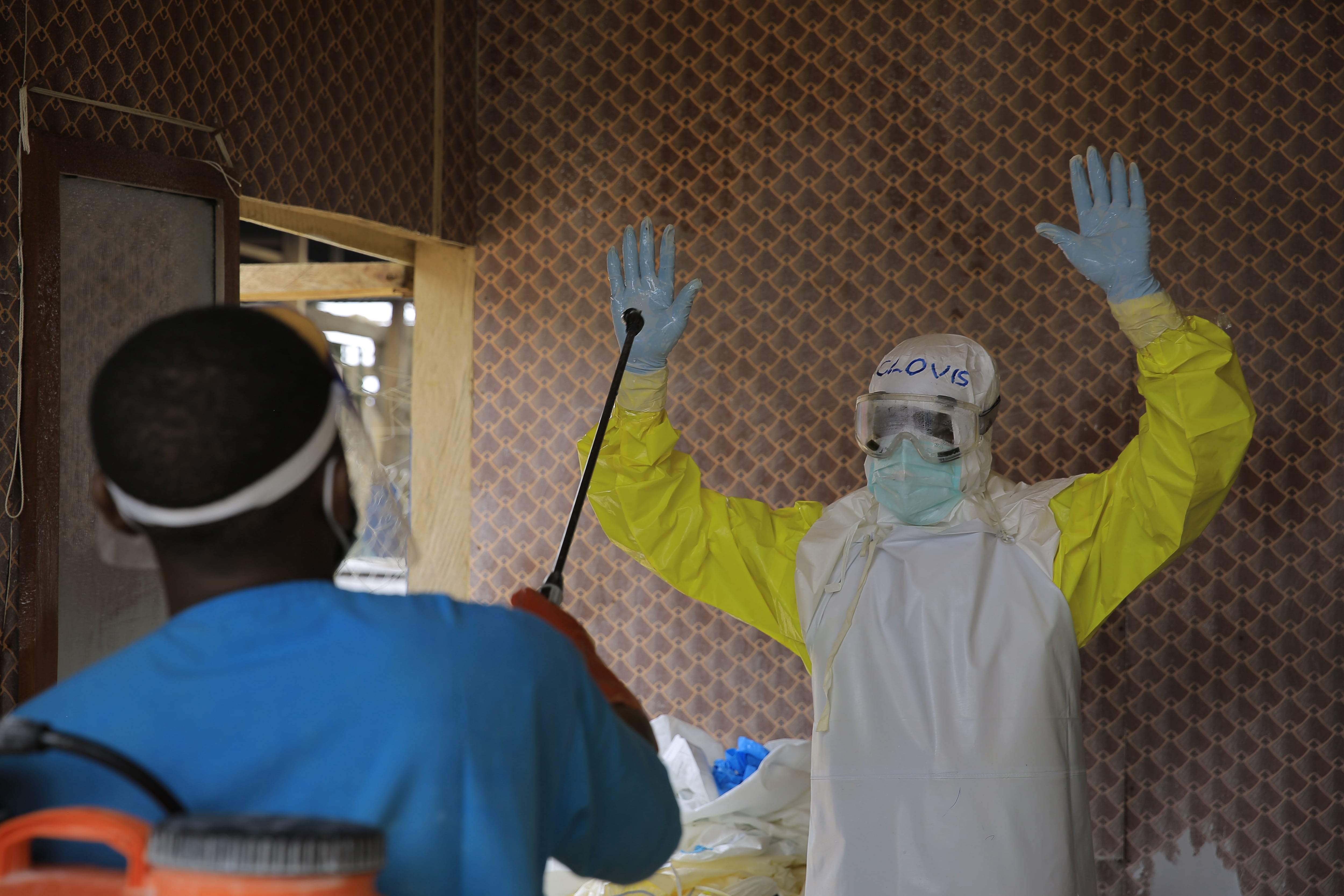 A healthcare worker is disinfected by a colleague inside a treatment center for Ebola patients in Beni, North Kivu province, eastern Congo, Tuesday, Oct. 27, 2026. (AP Photo/Sebastien Kitsa Musayi)
