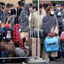 La gente se queda junto a una cerca en la base aérea de Ramstein U.S. en Ramstein, Alemania, lunes, 30 de agosto de 2021. La comunidad militar estadounidense más grande en el extranjero alberga miles de evacuados afganos en una ciudad de TENT en la barra aérea. (AP Foto / Matthias Schrader)