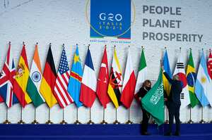 Operarios ajustan la bandera de Arabia Saudí antes de una foto grupal al inicio de la cumbre del G20 en Roma, el 30 de octubre de 2021. (AP Foto/Evan Vucci, Pool)