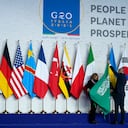 Operarios ajustan la bandera de Arabia Saudí antes de una foto grupal al inicio de la cumbre del G20 en Roma, el 30 de octubre de 2021. (AP Foto/Evan Vucci, Pool)