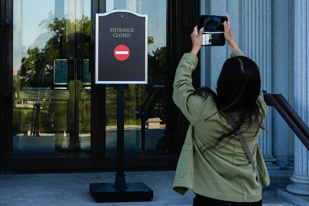 Un turista fotografía un cartel que anuncia el cierre de la Biblioteca del Congreso, el primer día del cierre parcial del gobierno, el miércoles 1 de octubre de 2025, en Washington. (Foto AP/Julia Demaree Nikhinson)