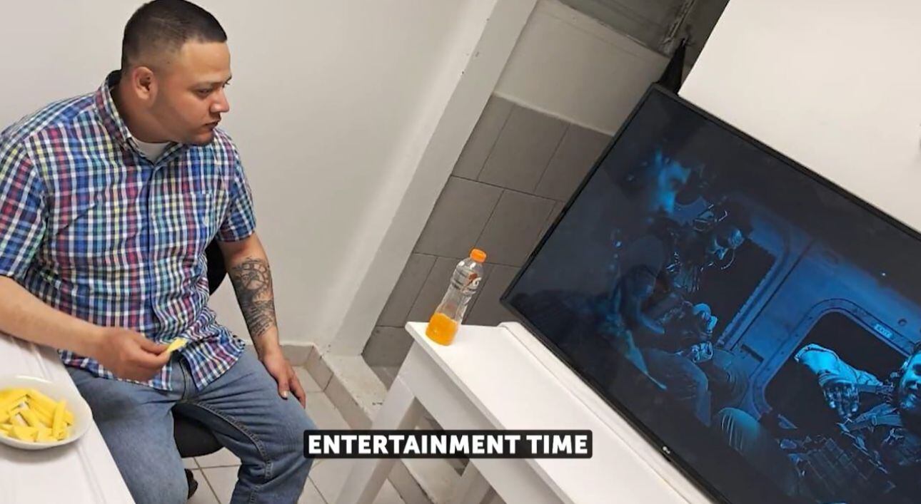 En las imágenes se puede ver al migrante salvadoreño comiendo y viendo una película en la megacárcel de El Salvador