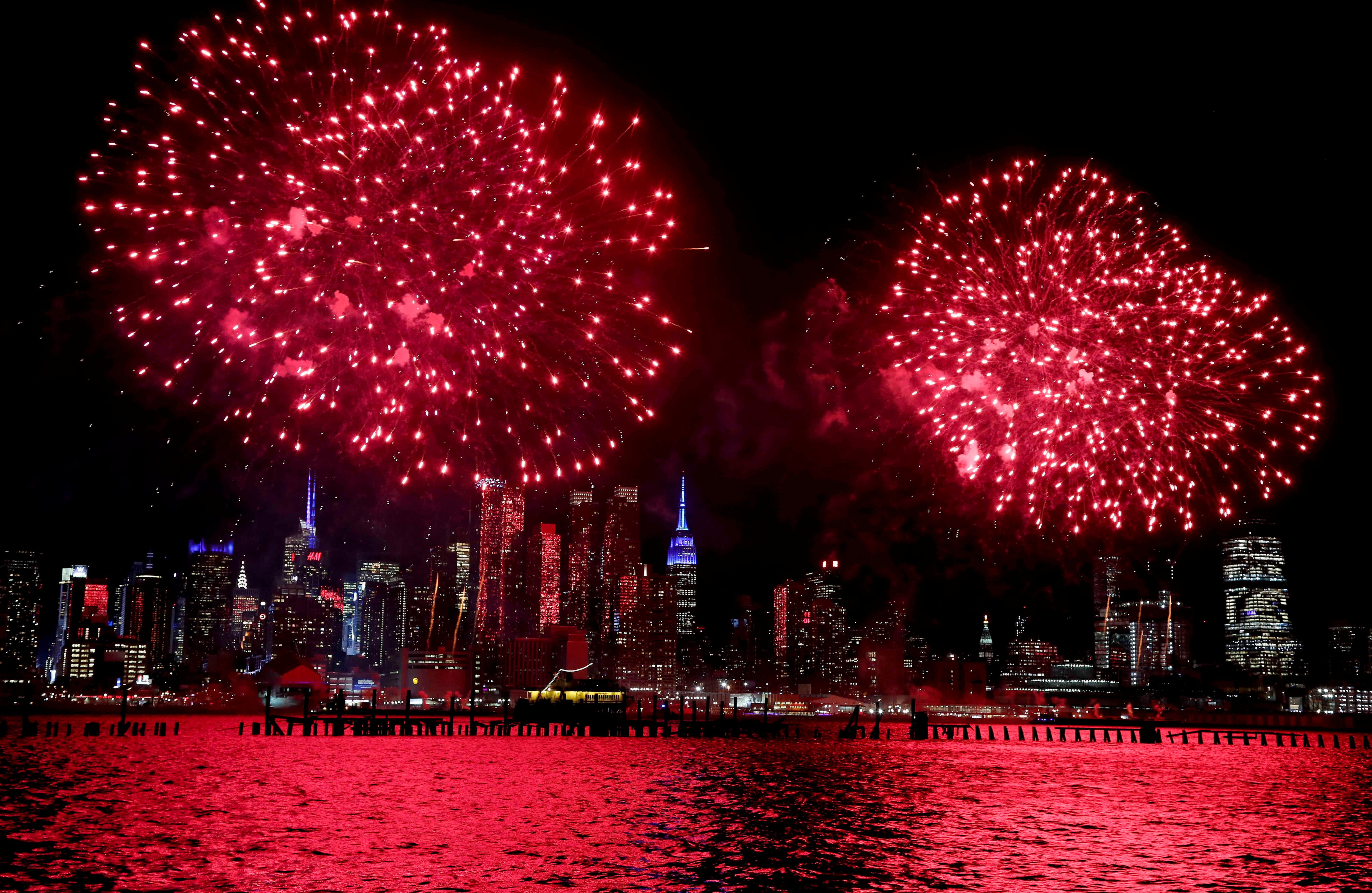 La punta del Empire State Building (centro) se enciende en azul mientras que los fuegos artificiales estallan sobre el río de Hudson que celebra el Año Nuevo lunar, el jueves, 26 de enero, 2017, visto desde Weehawken, N.J. (AP Photo / Julie Jacobson)