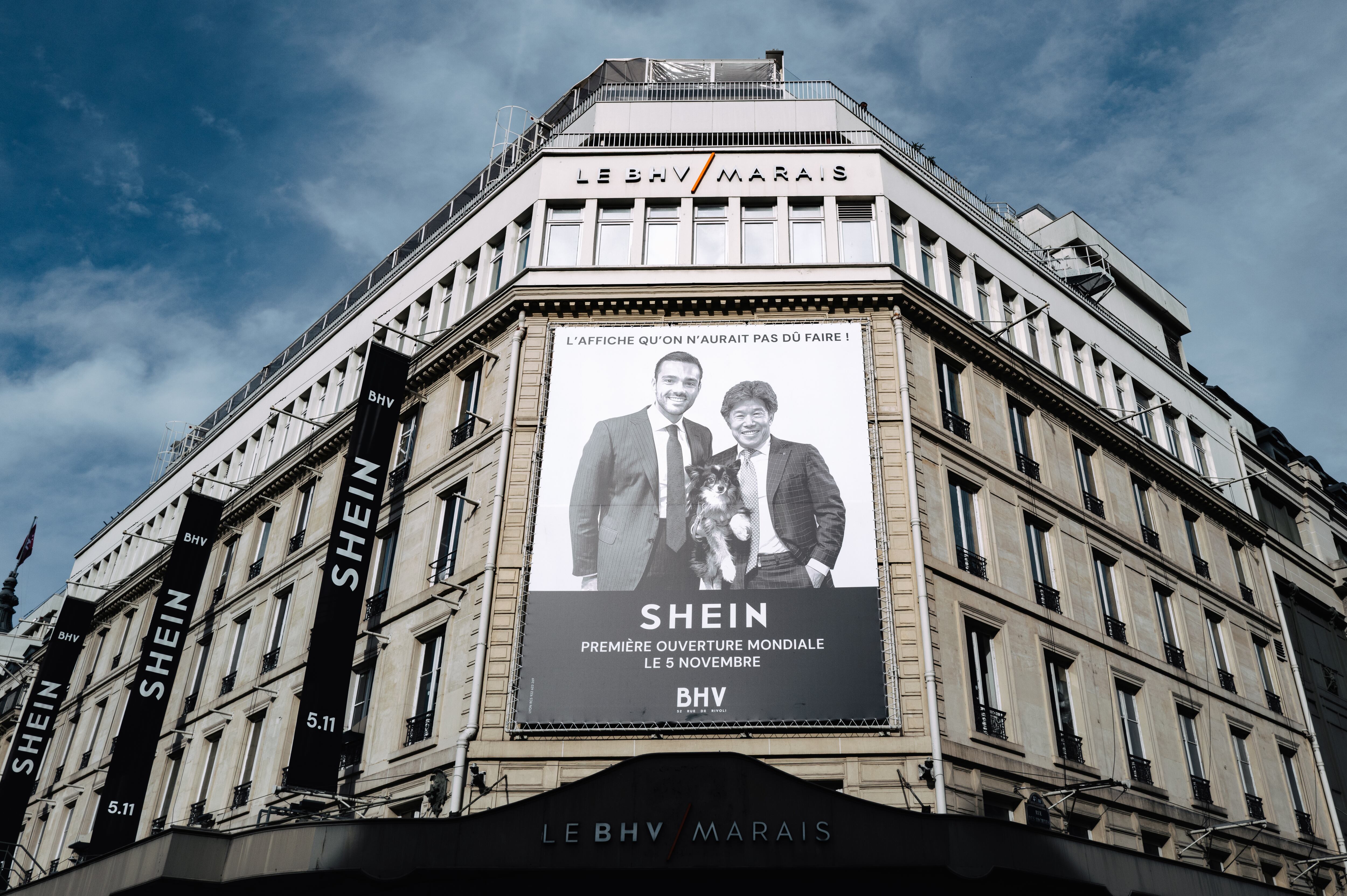 An overview of large banners and promotional visuals for Shein includes a giant poster depicting Frederic Merlin, president of the SGM group "Societe des Grands Magasins"owner of BHV Maraisalongside Donald Tang, executive president of the Shein group, outside at the Bazar de l'Hotel de Ville (BHV) department store in Paris, France, on November 5, 2025, on the opening day of its first physical store at BHV in Paris. Asian e-commerce giant Shein, a Singapore-based company originally founded in China, pledges on November 5, 2025, to "cooperate fully" with French judicial authorities as investigations launch after France's anti-fraud unit reports it is selling childlike sex dolls, and says it is prepared to disclose the names of people who bought them. (Photo by Jerome Gilles/NurPhoto via Getty Images)