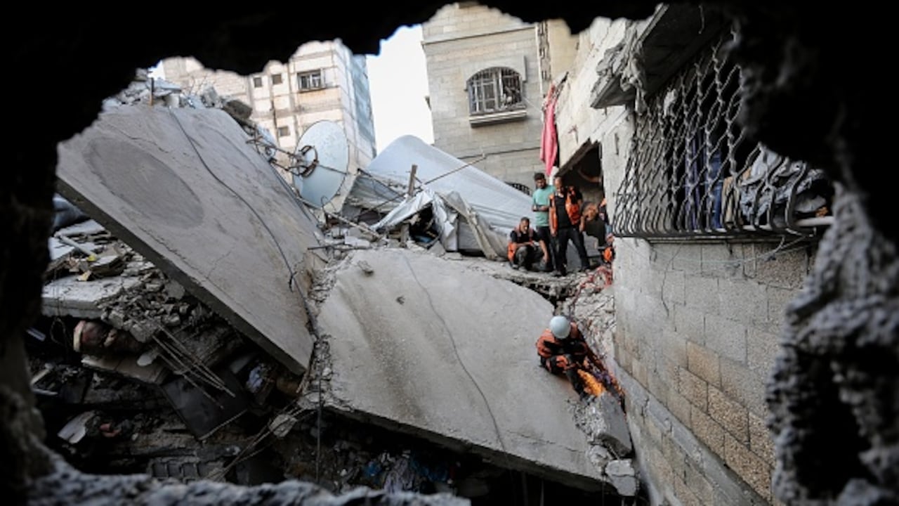 La gente busca en los edificios que fueron destruidos durante los ataques aéreos israelíes en el sur de la Franja de Gaza el 1 de noviembre de 2023 en Khan Yunis, Gaza. Al entrar en la tercera semana del conflicto, el ejército israelí ha ampliado su asalto militar.