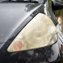 Damaged and blurred headlight surface as a result of weather condition and aging of a car