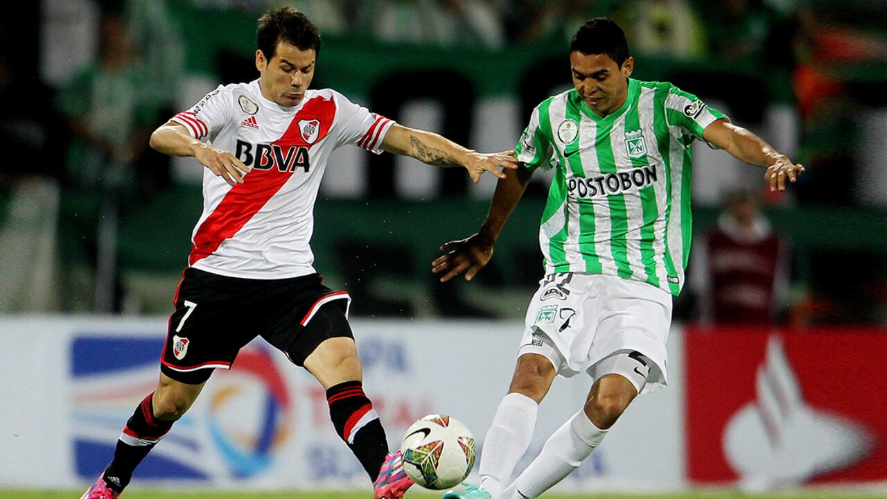 El jugador Rodrigo Mora del River Plate disputa un balón con Daniel Bocanegra del Atlético Nacional.