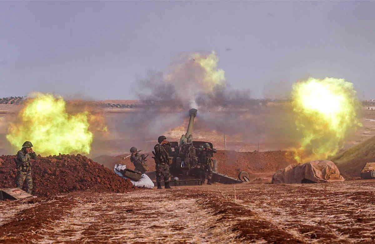 Una imagen publicada por la Agencia Oficial de Noticias Árabe-Siria muestra las armas de artillería del ejército sirio disparando desde un lugar en al-Habit, en la frontera sur de la provincia de Idlib, el 22 de octubre de 2019. (Foto: SANA / AFP)