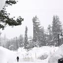 MAMMOTH LAKES, CALIFORNIA - 10 DE MARZO: Una bandera estadounidense cuelga frente a un negocio mientras la nieve cae sobre los bancos de nieve acumulados de tormentas anteriores durante otra tormenta de invierno en las montañas de Sierra Nevada el 10 de marzo de 2023 en Mammoth Lakes, California. Las montañas de Sierra Nevada de California están siendo golpeadas por fuertes nevadas en elevaciones más altas, lo que eleva aún más los niveles de la enorme capa de nieve. Las comunidades de las montañas que aún se están recuperando de tormentas anteriores en elevaciones más bajas se enfrentan a posibles inundaciones debido a la escorrentía de lluvia de la décima tormenta fluvial atmosférica del estado. El presidente Joe Biden aprobó la solicitud de emergencia presidencial del gobernador Gavin Newsom en respuesta a las recientes tormentas que afectaron a California. Mario Tama/Getty Images/AFP (Foto de MARIO TAMA/GETTY IMAGES NORTH AMERICA/Getty Images vía AFP)