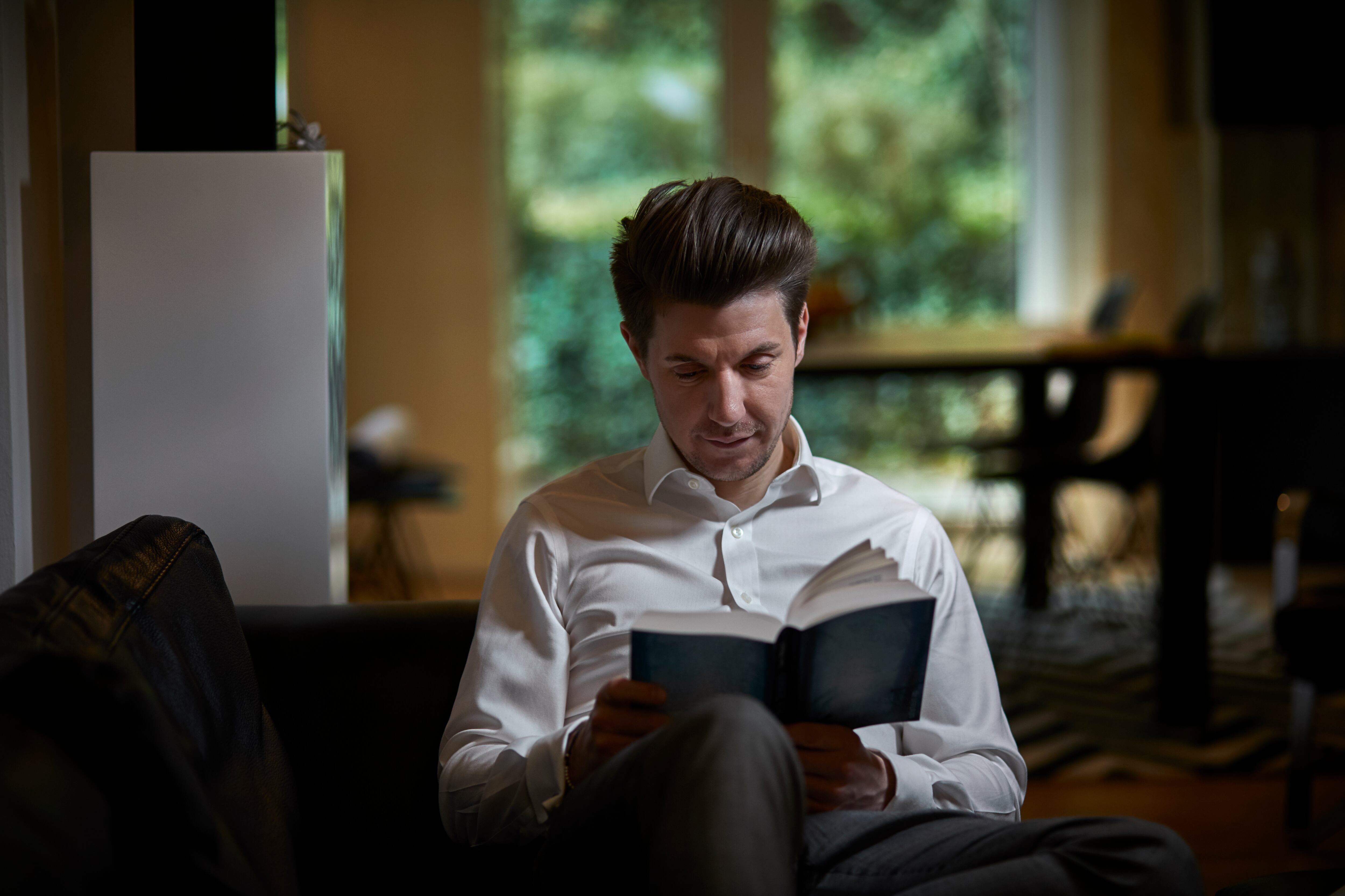 Hombre de negocios, en, sofá, leer un libro, hombre leyendo un libro, lectura.