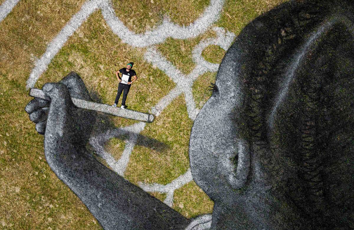 Vista aérea de una pintura Land Art del artista francés suizo Saype titulada "World in Progress", en la sede europea de las Naciones Unidas, en Ginebra, Suiza, el 24 de junio. La obra de arte de 6.000 metros cuadrados fue producida con pinturas biodegradables hechas de pigmentos naturales como carbón y tiza. Foto: Valentin Flauraud/Keystone via AP