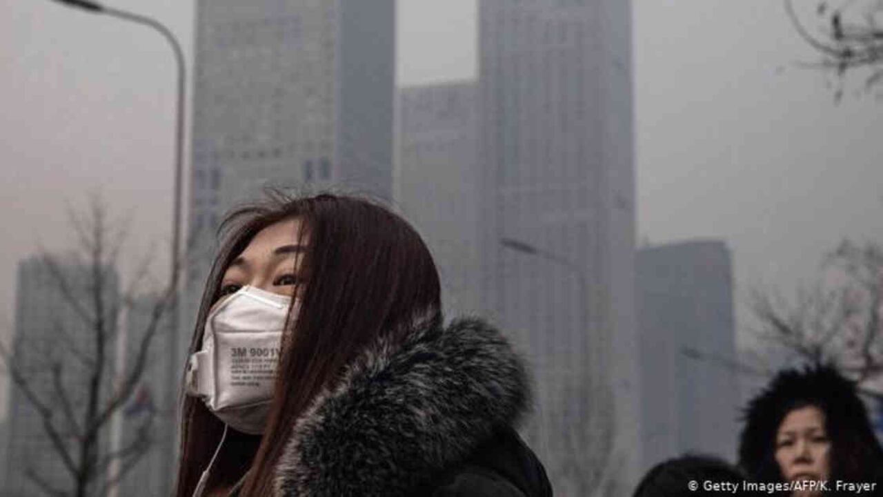 Mujer utilizando una mascarilla en la contaminada ciudad de Pekín. Foto: Getty Images vía DW.