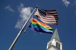 Archivo - Una bandera arcoíris del Orgullo gay ondea junto a la bandera de Estados Unidos frente a un templo de la Iglesia Metodista Unida de Asbury en Prairie Village, Kansas, el 19 de abril de 2019. (AP Foto/Charlie Riedel, Archivo)