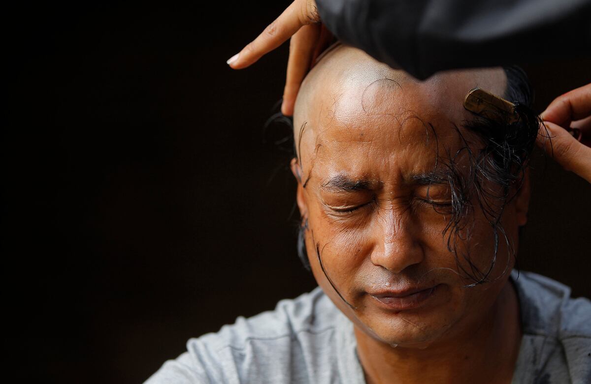 Un nepalés que perdió un familiar en el terremoto de abril se prepara para atravesar el final de su duelo durante un ritual en el río Hanumante, en la ciudad de Bhaktapur, Nepal. (AP/Niranjan Shrestha)