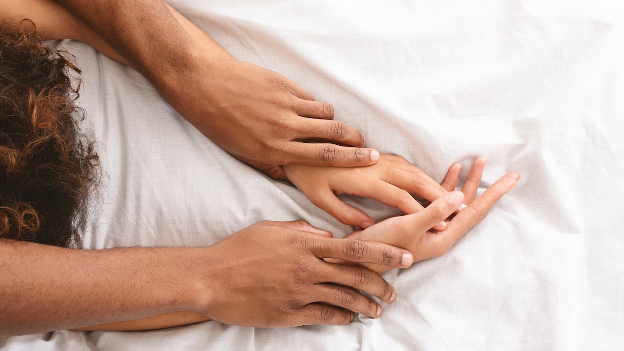Black man and woman enjoying sexual foreplay in bed, free space